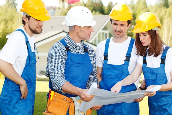 Workmen looking at house design