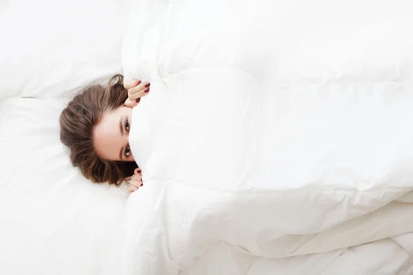 Woman in bed under the blanket