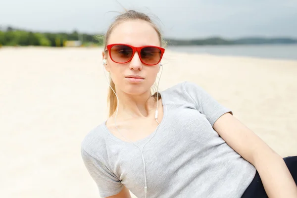Sports girl on the beach wearing sunglasses
