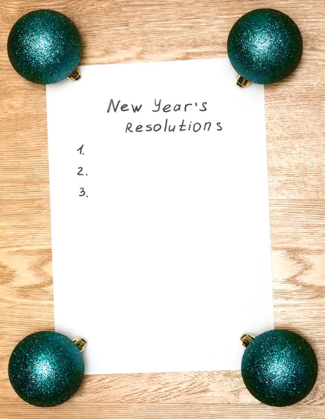 New Year resolutions on a blank list on wooden background