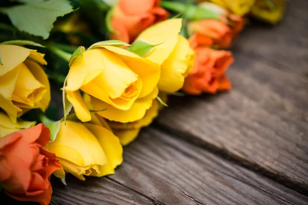 Yellow and orange roses on a wooden background. Women\' s day, Va