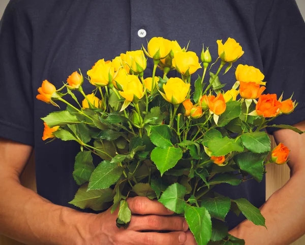 Man holding bouquet of yellow and orange roses. Women\' s day, Va
