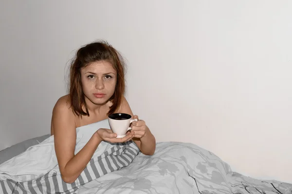 Woman drinking coffee in bed