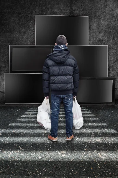 A young boy stays in front of tv screens and looking to the tv static pictures