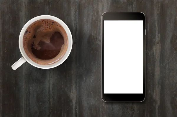 Smart phone with isolated white display for mockup. Top view scene with coffee.