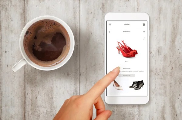 Woman shopping shoes with smart phone. Top view scene with coffee.