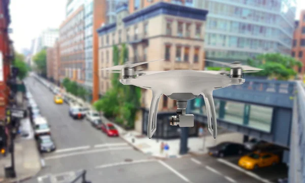 Drone quad copter with camera oversees the city streets.