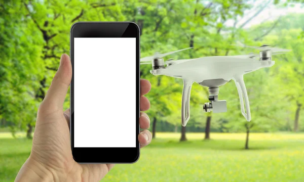 Smart phone with isolated white screen control drone. Park in background.
