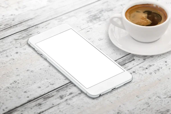 Smart phone with blank screen for mockup. Cup of coffee beside on table. Isometric view.