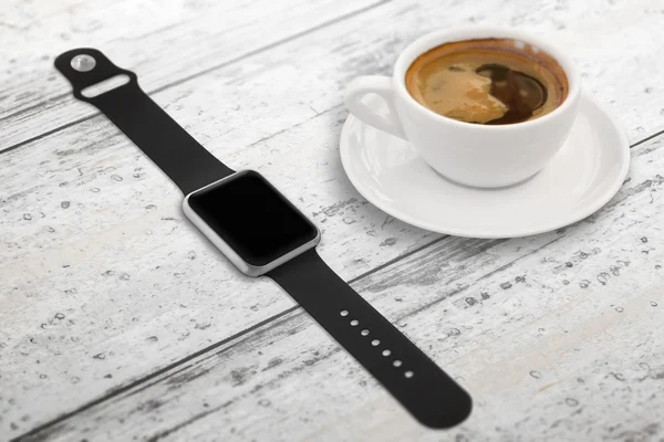 Smartwatch with blank screen for mockup. Isometric view. Cup of coffee beside on table.