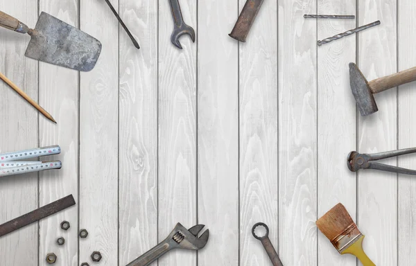 Old construction tools with free space for text. Hammer, chisel, brush, paint, wood plane, ruler, shavings, jointer, nail, wrench.