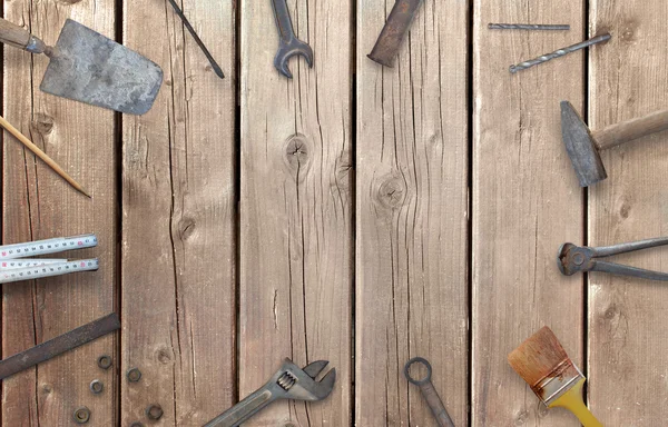 Old construction tools with free space for text. Hammer, chisel, brush, paint, wood plane, ruler, shavings, jointer, nail, wrench.