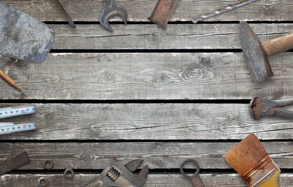 Old construction tools with free space for text. Hammer, chisel, brush, paint, wood plane, ruler, shavings, jointer, nail, wrench.