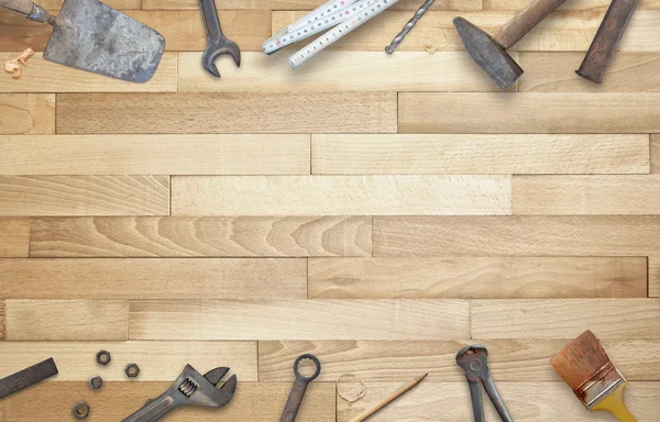 Old construction tools with free space for text. Hammer, chisel, brush, paint, wood plane, ruler, shavings, jointer, nail, wrench.