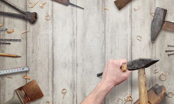 Carving with a chisel on wooden surface. Free space for text. Old tools beside.