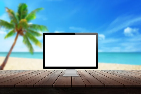 Computer display on desk with beach palm tree and sea in the background mock up presentation