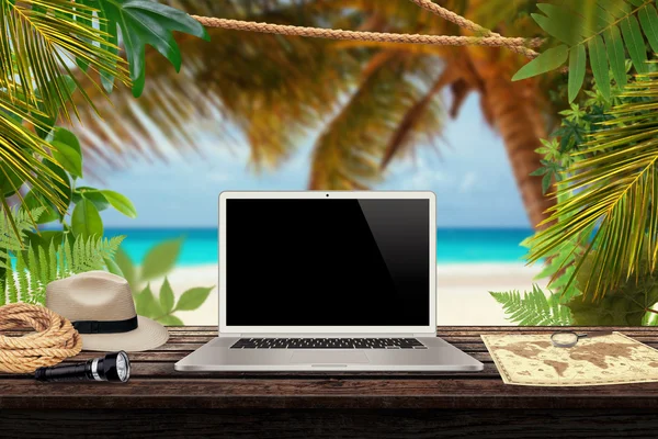 White laptop map hat rope torch on the table with sea and jungle in the background mockup presentation