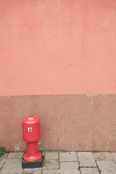 Detail of a red wall with hydrant from Burano island, Venice