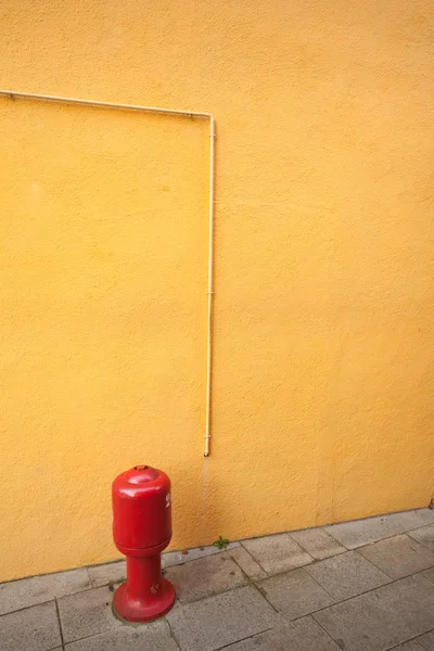 Detail of a yellow wall with hydrant from Burano island, Venice