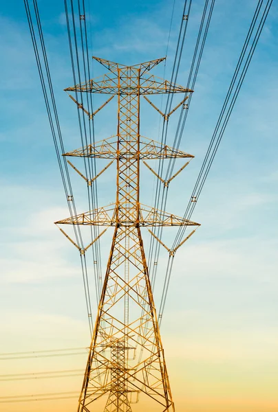 High voltage transmission lines on orange and blue sky, sunrise period