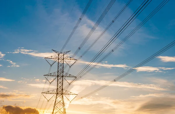 High voltage transmission lines on orange and blue sky, sunrise