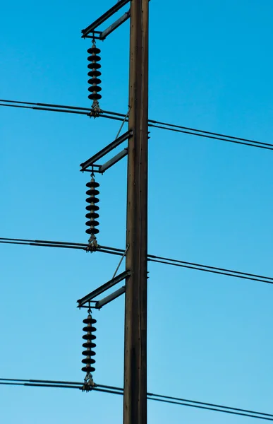 Silhouette of Electricity post in dark blue sky background