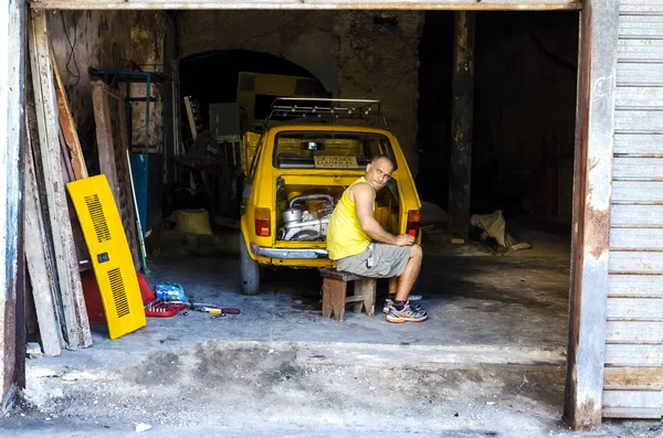 Mechanic and yellow cuban car