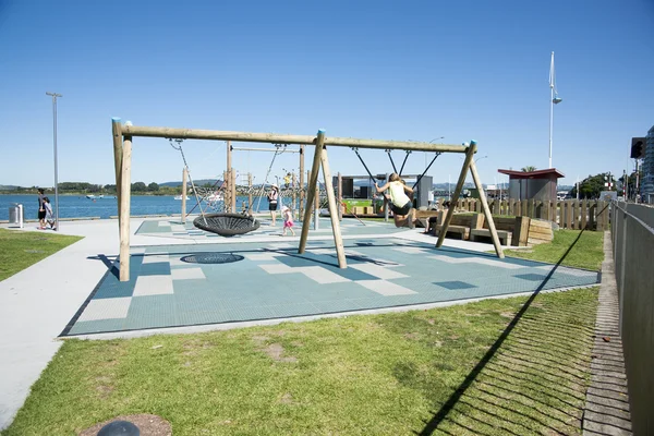 TAuranga waterfront playground swings being enjoyed by children