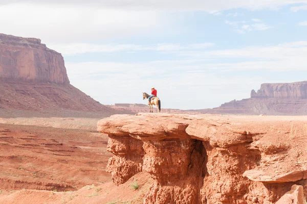 Cowboy caught in sun on rock bluff in Monument Valley Utah USA