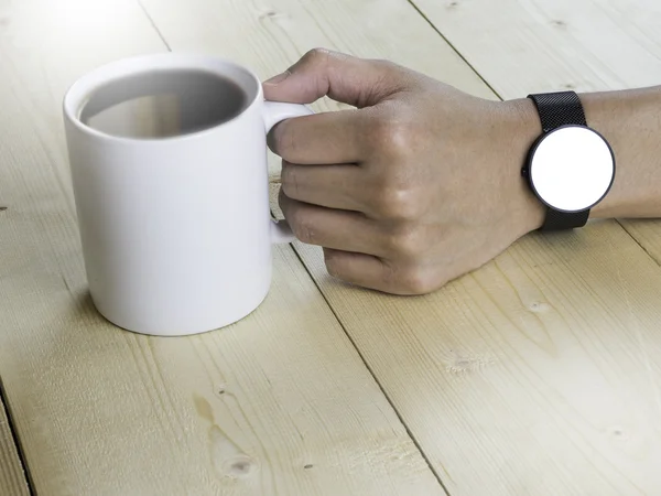 White screen on smart watch hand holding coffee mug