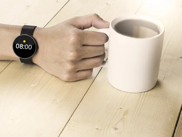 8 o\' clock on smart watch hand holding coffee mug