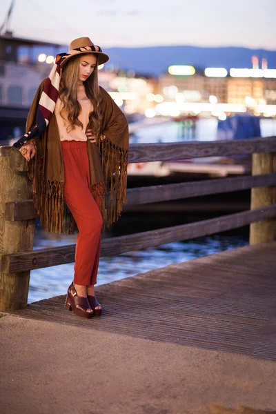 Beautiful attractive and stylish girl in hat posing in city.