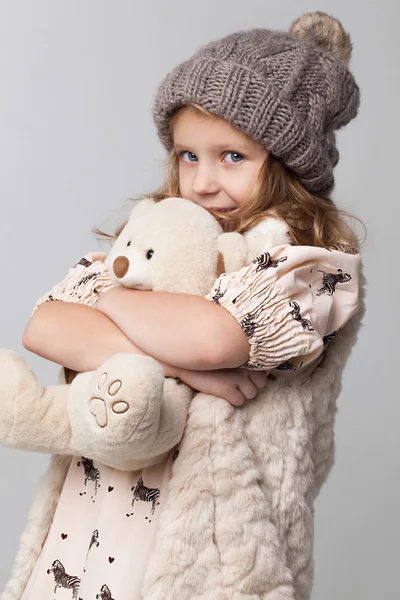 Little girl taking small toy bear