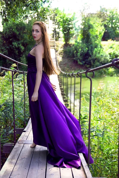 Young beauty woman in fluttering lilac dress