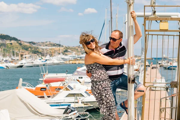 The Italian coast. Seaport. Young cute couple in love walking in the port