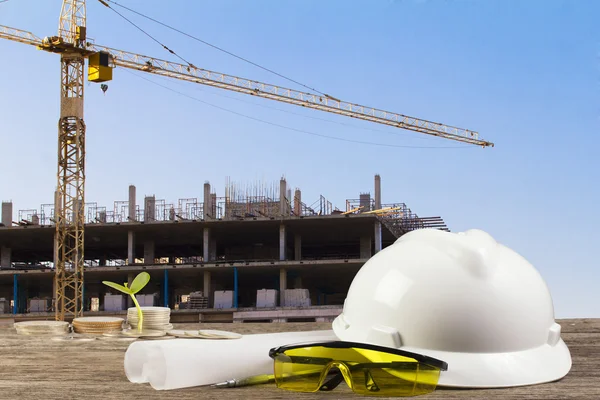 Business Growing  file of safety helmet and architect plant on wood table with  construction