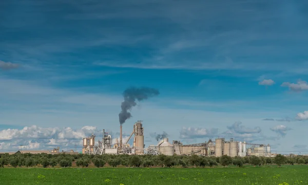 Green Field And Factory With Dark Smoke Coming Out Of Chimney