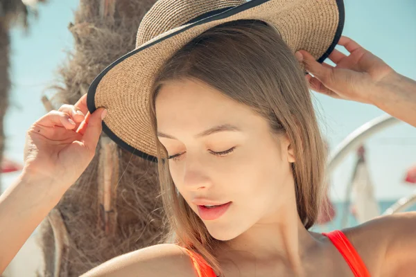 Summer concept - young woman in swimsuit and sun hat