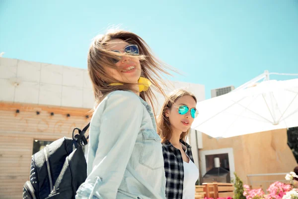 Lifestyle of two best friends laughing outdoor on the street