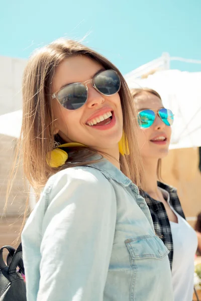 Lifestyle of two best friends laughing outdoor on the street