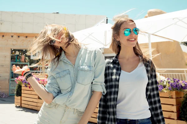 Lifestyle of two best friends laughing outdoor on the street