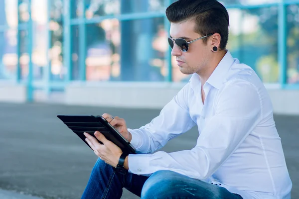 Businessman outside building with electronic tablet