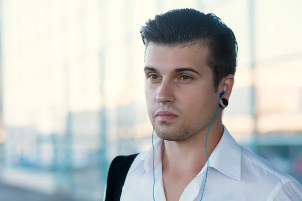 Handsome man listening music on a sunny summer day