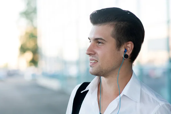 Handsome man listening music on a sunny summer day