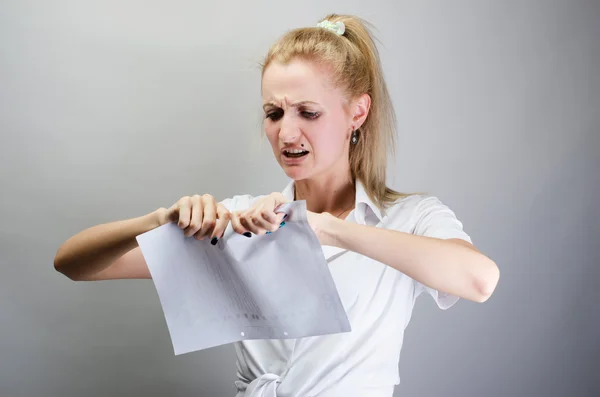 Woman tears contracts, white sheet of paper. On a gray background.