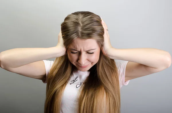 Too loud sound. woman covering ears with hands and keeping eyes closed