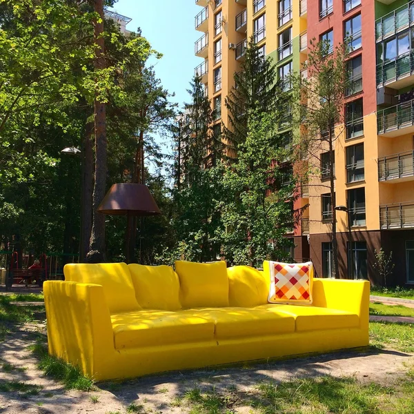 Yellow sofa in yard in front of house