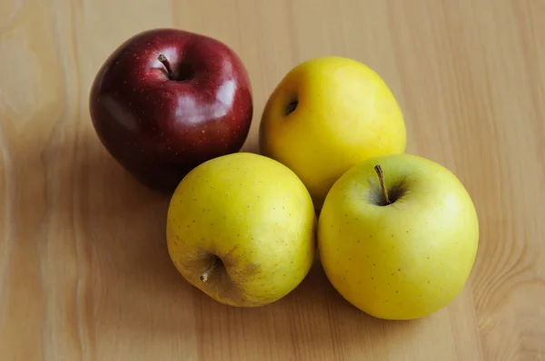 Red and yellow apples in table