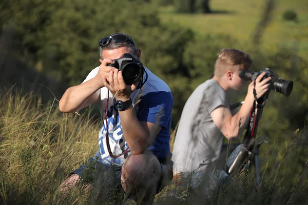 Photographers father and son take off in nature. The father teaches his son the right to use the camera. The meeting of two friends