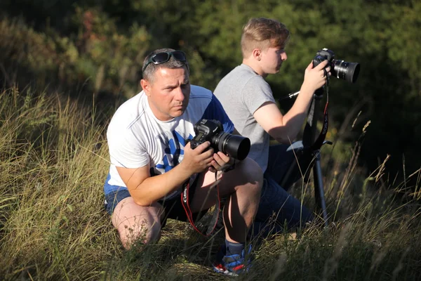 Photographers father and son take off in nature. The father teaches his son the right to use the camera. The meeting of two friends